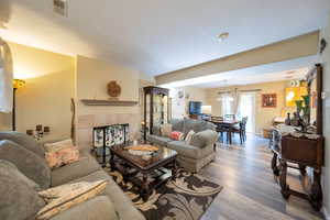 Living room featuring a fireplace, hardwood / wood-style flooring, and a chandelier