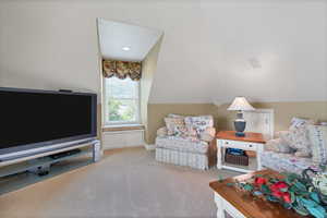 Festive sitting  area featuring lofted ceiling and ceiling fan