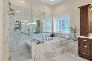 Primary bathroom newly remodeled with vanity, crown molding, and separate shower and tub