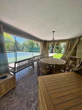 Sunroom / solarium with a chandelier off tennis/pickleball courts