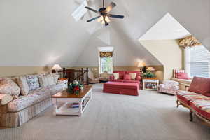 Festive sitting  area featuring lofted ceiling and ceiling fan