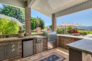 View of patio / terrace featuring a mountain view, an outdoor kitchen, and grilling area off pool