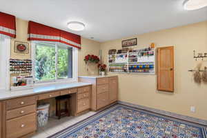 Laundry room featuring stacked washer / drying machine, cabinets, sewing area and wrapping area