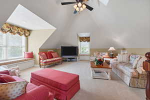 Festive sitting  area featuring lofted ceiling and ceiling fan