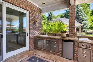 View of patio with a grill, sink, and exterior kitchen off pool