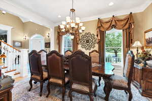 Dining area featuring crown molding, wood-type flooring, and an inviting chandelier