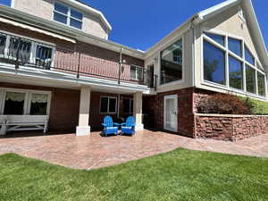 Rear view of property with a patio, a yard, and a balcony facing Ash Creek