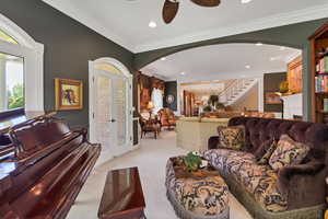 Living area off entrance  featuring ornamental molding, fireplace and built-in bookshelf