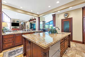 Kitchen featuring light stone countertops, in island drawer refrigerators