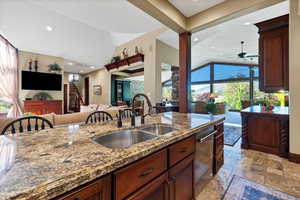 Kitchen with a wealth of natural light, sink, and dark stone counters