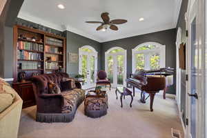 Living area off entrance  featuring ornamental molding, fireplace and built-in bookshelf