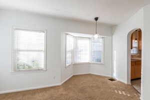 Unfurnished dining area with light colored carpet