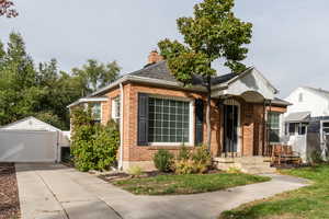 View of front of property with a garage and an outbuilding