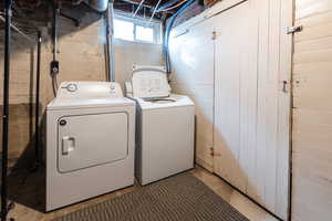 Clothes washing area with independent washer and dryer and wood walls