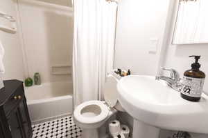 Full bathroom featuring toilet, sink, and shower / bath combo