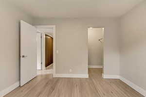 Bedroom featuring a spacious closet, a closet, and light wood-type flooring