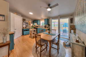 Dining space featuring lofted ceiling, sink, light hardwood / wood-style floors, and ceiling fan