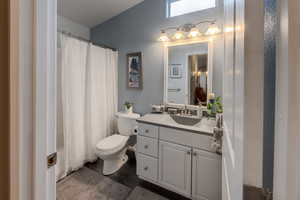 Full bathroom featuring vanity, shower / bath combination with curtain, toilet, and wood-type flooring