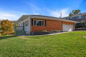 View of front of house featuring a garage and a front lawn