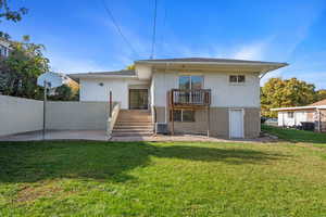 Rear view of house featuring a patio, central AC, and a lawn