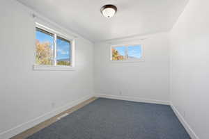 Carpeted empty room featuring a textured ceiling and a wealth of natural light