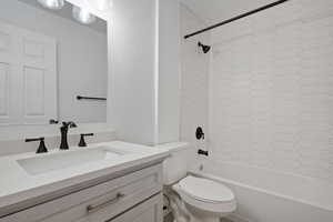 Full bathroom featuring vanity, toilet, and tiled shower / bath combo