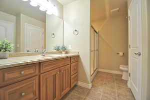 Bathroom featuring vanity, toilet, and an enclosed tub/shower