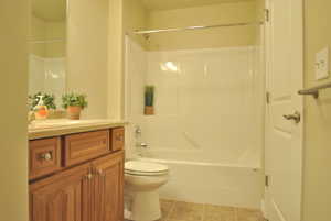 Full bathroom featuring vanity, toilet, tile patterned floors, and bathing tub / shower combination