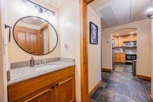 Bathroom with vanity and tasteful backsplash