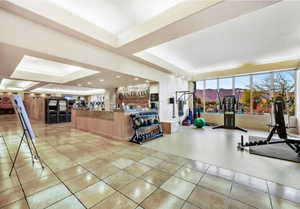 Interior space featuring light tile patterned flooring and a raised ceiling