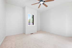 Carpeted empty room with ceiling fan