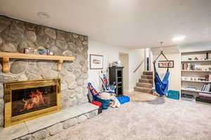 Playroom featuring a stone fireplace and carpet flooring