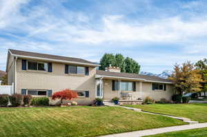 Tri-level home with a mountain view and a front lawn