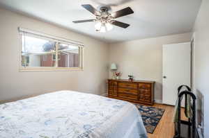 Bedroom with hardwood / wood-style floors and ceiling fan