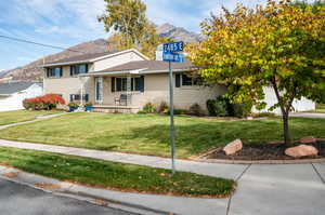 View of front of house with a mountain view and a front lawn