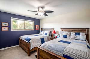 Carpeted bedroom featuring ceiling fan