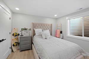 Bedroom featuring light wood-type flooring and multiple windows