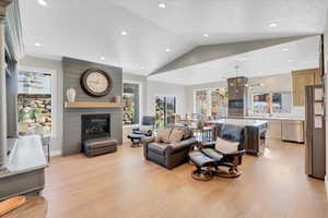 Living room featuring a wealth of natural light, light hardwood / wood-style floors, and lofted ceiling