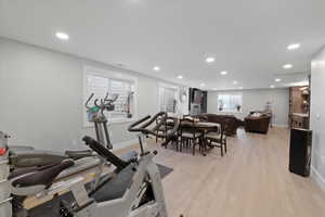 Exercise room with light hardwood / wood-style floors