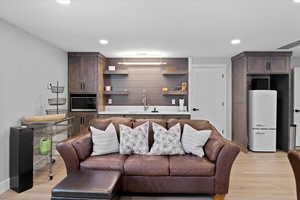 Living room with light hardwood / wood-style flooring and indoor wet bar