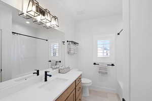 Bathroom with tile patterned flooring, vanity, and toilet