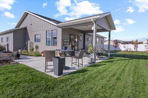 Rear view of property with a patio and a yard