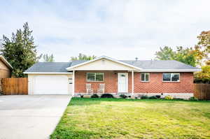 Ranch-style house with a front lawn and a garage