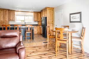 Kitchen featuring sink, black refrigerator, and light hardwood / wood-style flooring