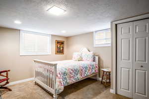 Carpeted bedroom featuring a closet and a textured ceiling