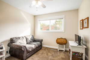 Living area featuring carpet and ceiling fan