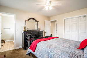 Carpeted bedroom with a closet and ceiling fan