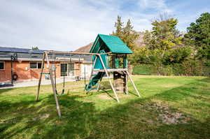 View of play area featuring a patio area, a lawn, and a pergola