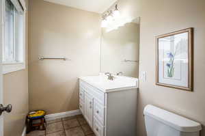 Bathroom featuring vanity, toilet, and tile patterned flooring