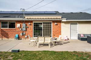 Back of house featuring a patio area and solar panels